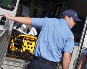 EMS worker holding ambulance door.