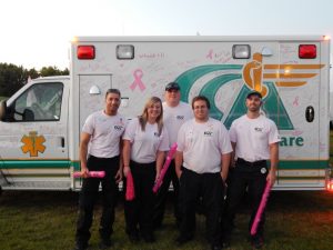 Community Care Ambulance Paramedics in front of an ambulance.