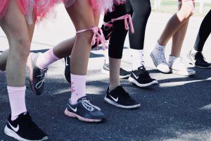 women wearing pink socks and ribbons running